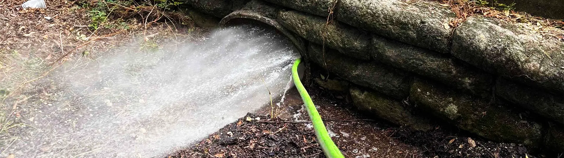 EVERYDAYPLUMBER.com hydro jetting hose blasting water through commercial drain access — high-pressure drain cleaning Tampa Bay