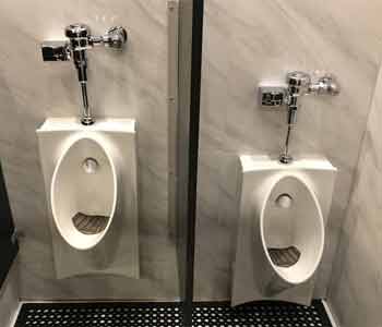 Two White Urinals With Chrome Flush Valves