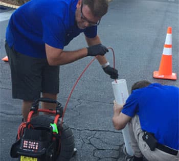Plumbers Using Drain Inspection Camera in Sewer Line