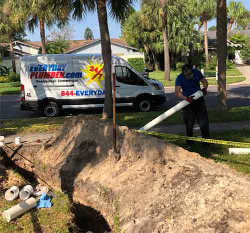 Plumber Putting New PVC Sewer Pipe in Trench - Clearwater Plumbers