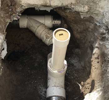 Spot repair of a sewer line with a clean out installation and brass cap