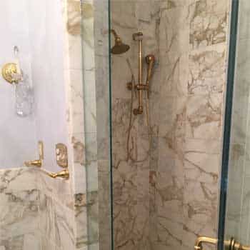 Shower Stall With Gold Shower Handle and Shower Head