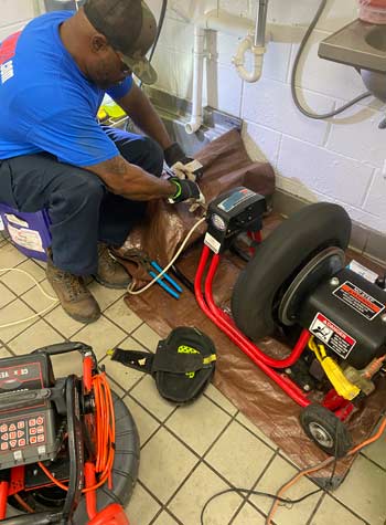 Plumber using a cable machine on a clogged drain