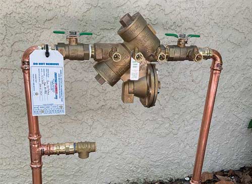Brass backflow prevention device with annual inspection tag