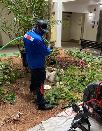 Plumber Hydro Jetting a Sewer Line in Apartment Complex Atrium