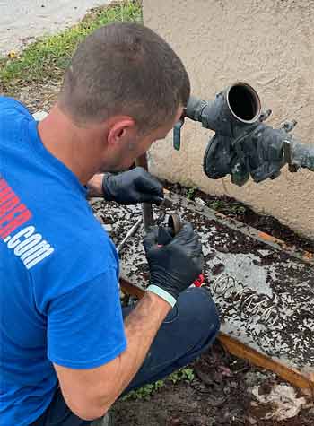 Plumber from EVERYDAYPLUMBEr.com on an emergency plumbing call for a badly  leaking backflow prevention device