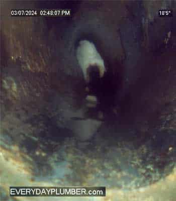 View inside sewer pipe showing grease build up