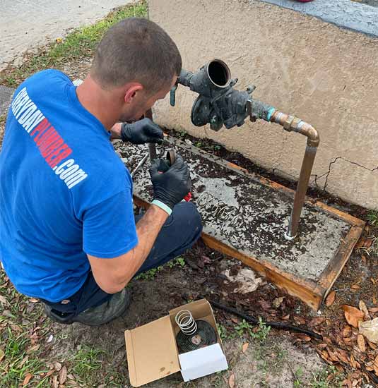 Emergency plumber fixing a leaking backflow device in Indian Rocks Beach, FL