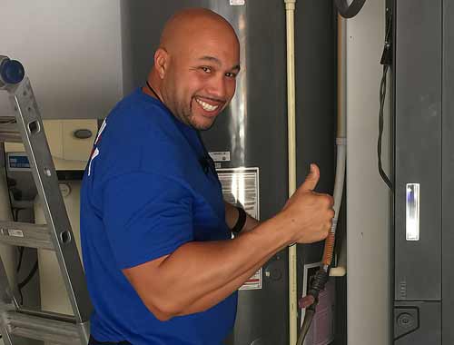 Plumber giving a thumbs up and smiling after installing a water heater