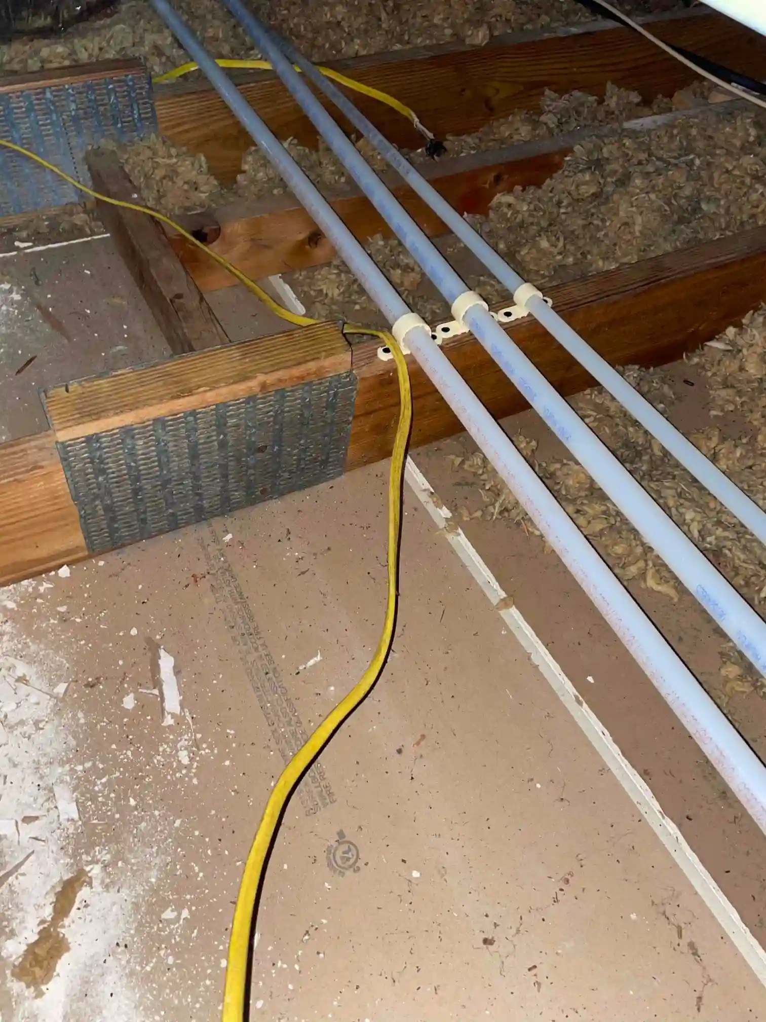 New PEX water lines secured between floor joists in an attic during a whole-house re-pipe