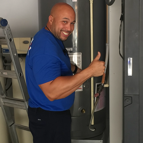 EverydayPlumber.com technician giving a thumbs up next to a water heater after a successful repair in Wesley Chapel