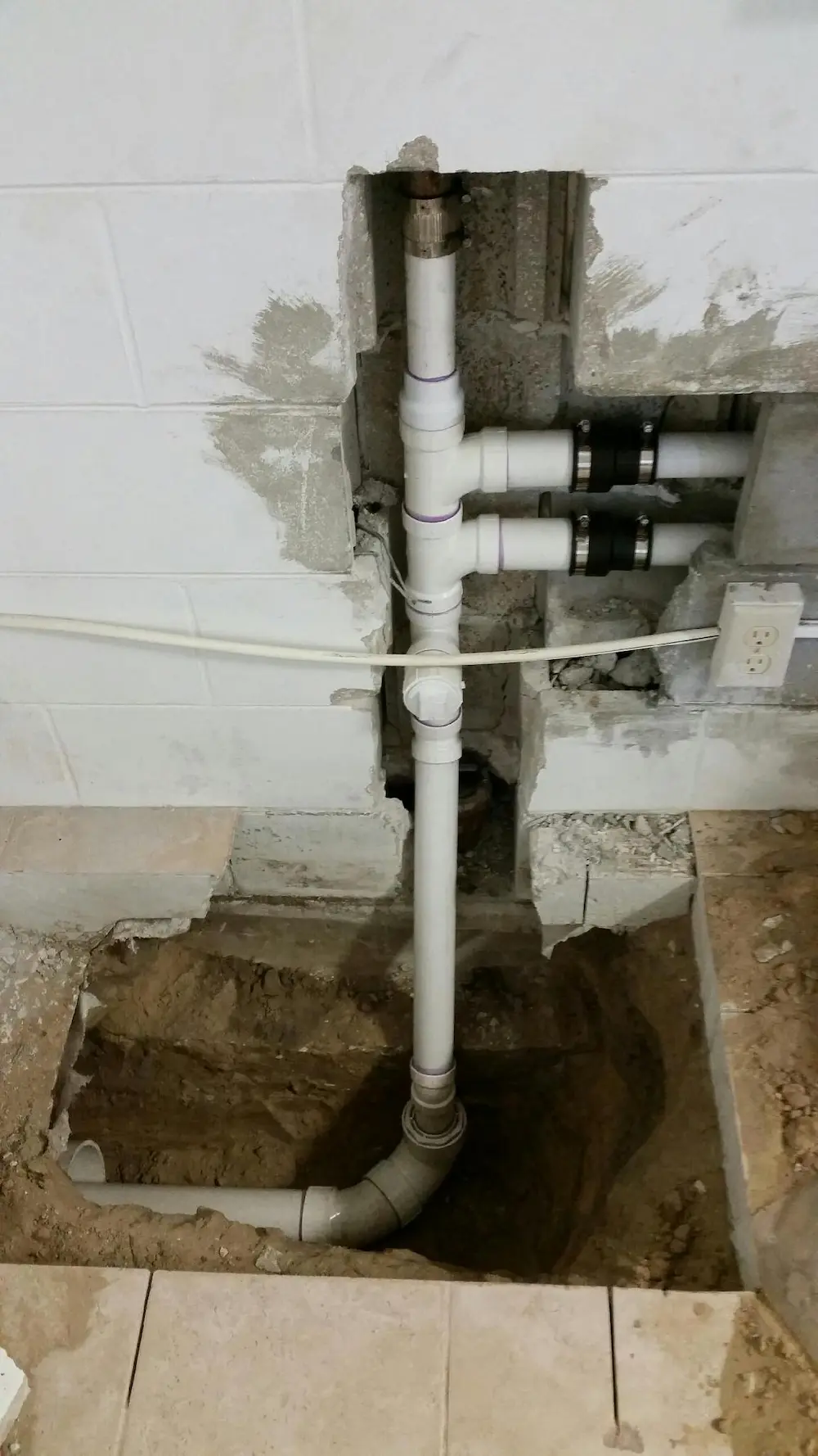 New PVC drain line installed inside a wall and under a slab after drain repair by a Hillsborough County plumber.