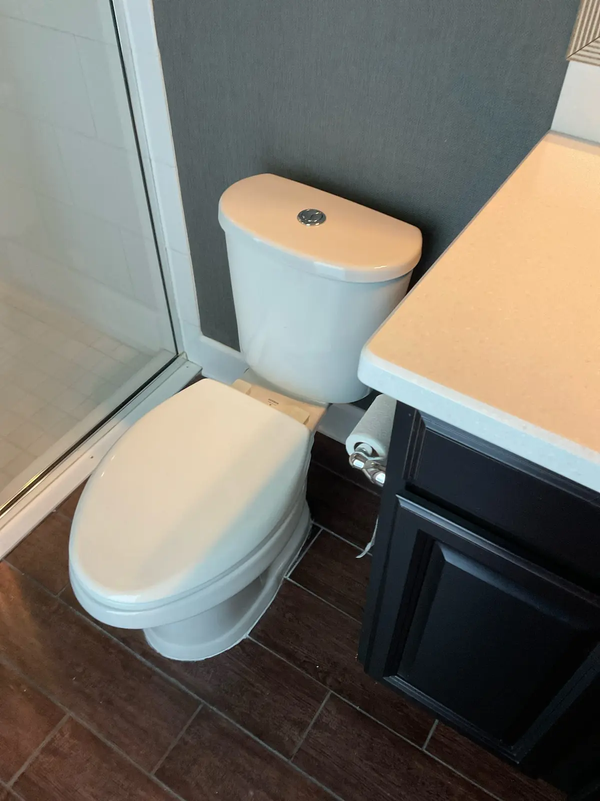 toilet-installation-bathroom-upgrade-tampa Newly installed toilet in modern Tampa bathroom, with clean tile floor and updated vanity, after professional plumbing repairs.