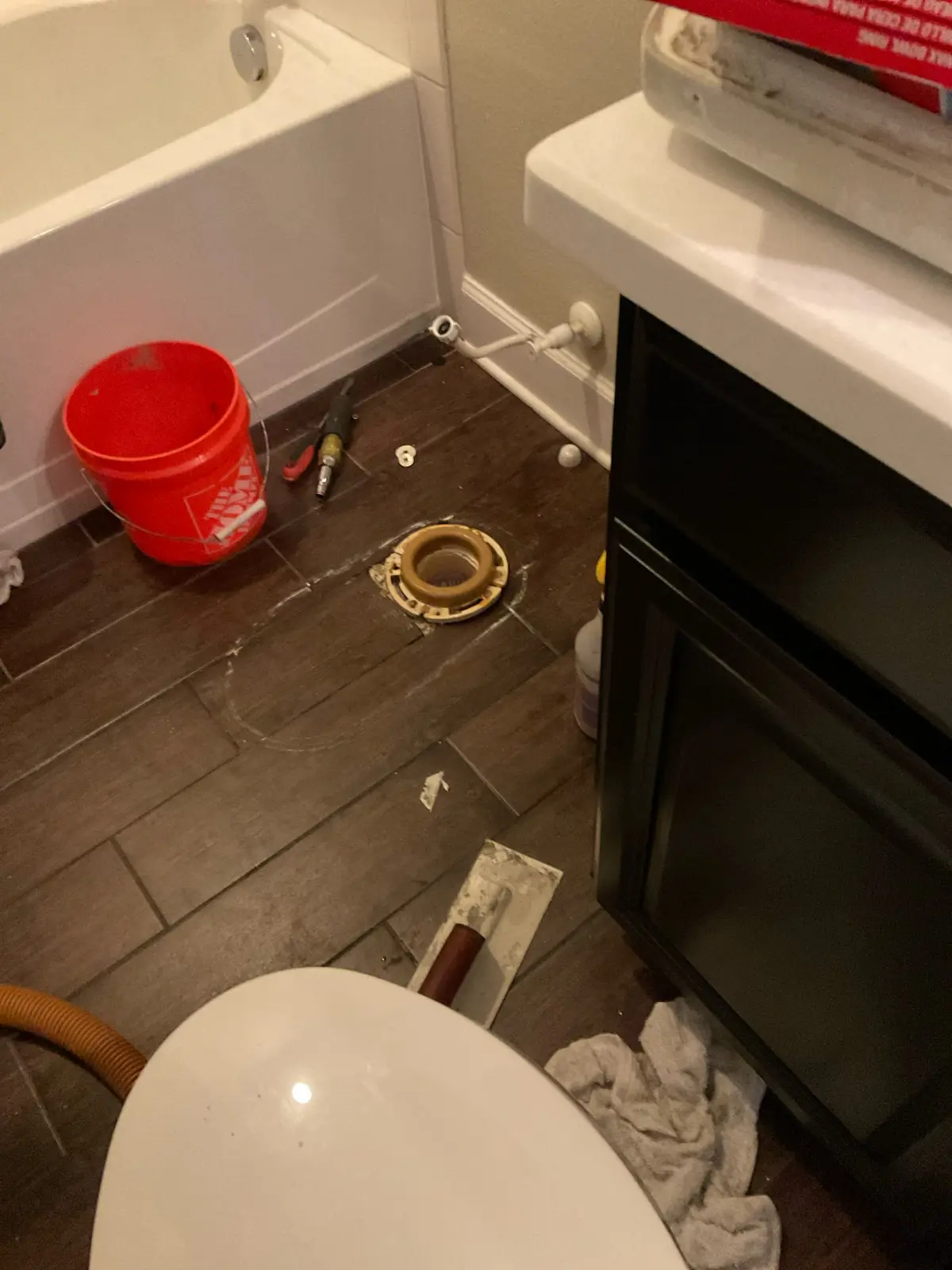 toilet-removal-bathroom-repairs-tampa Bathroom during toilet removal showing exposed toilet flange, tools, and bucket—part of a plumbing repair project in Tampa.