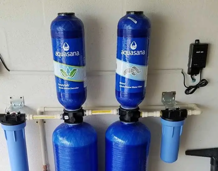Whole house water filtration system with two Aquasana filter tanks installed on wall