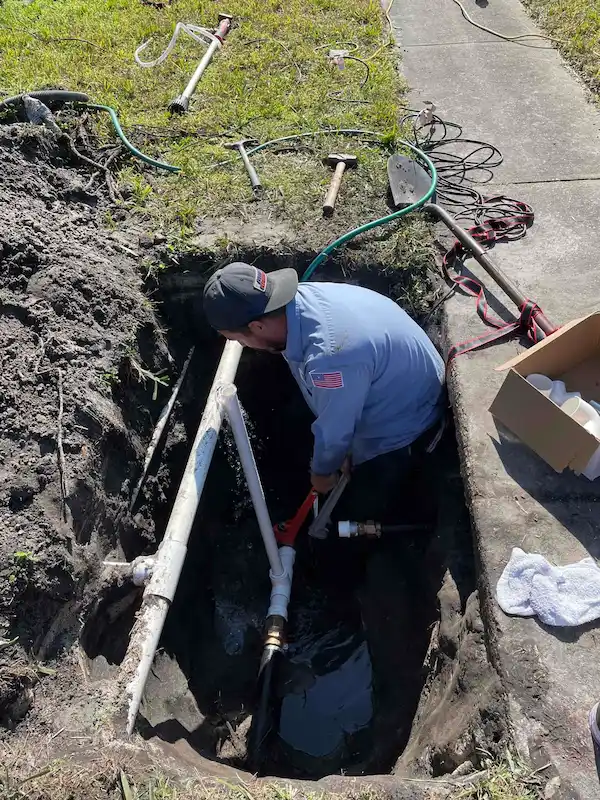 Avila plumber performing underground water service line repair near sidewalk