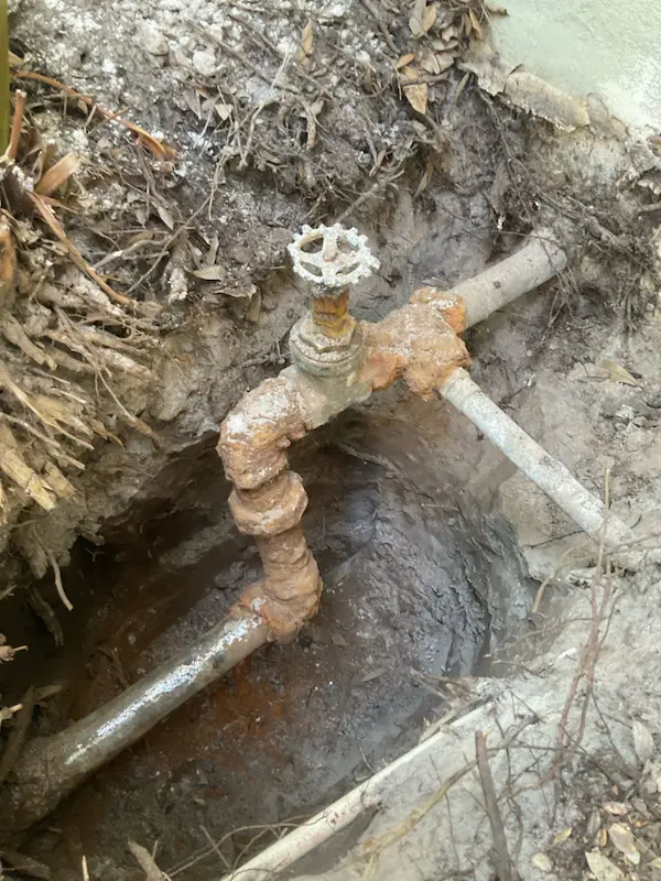 corroded-outdoor-plumbing-tampa Severely corroded outdoor plumbing with rusted shut-off valve before replacement by a top plumber in Tampa.