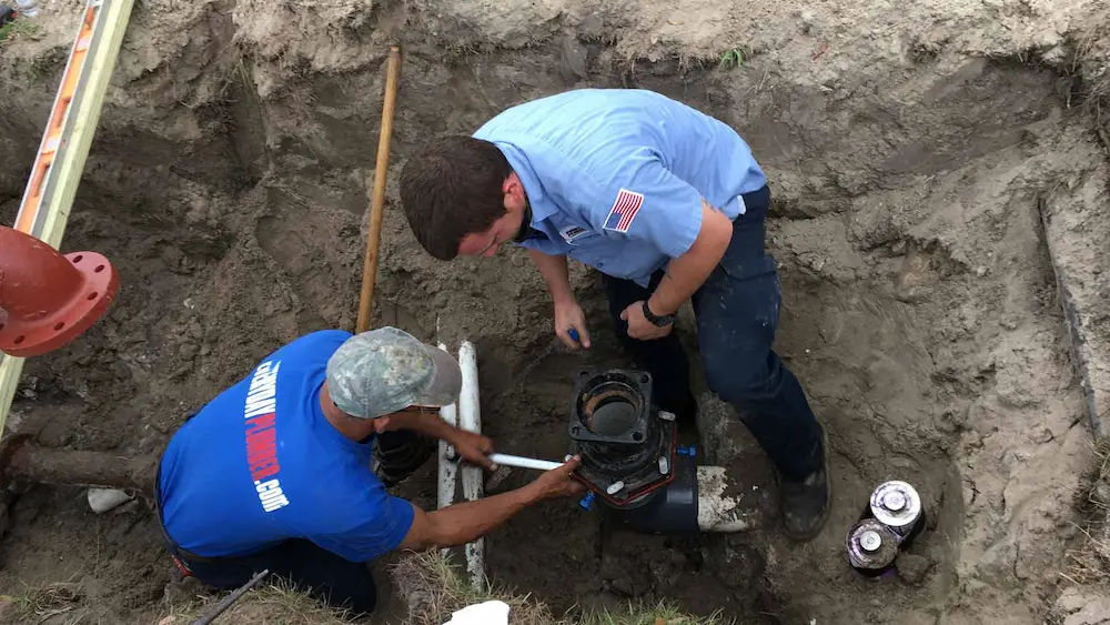 Two EVERYDAYPLUMBER.com technicians working neatly in an excavated trench, demonstrating professional and clean plumbing practices in Tampa, Florida.