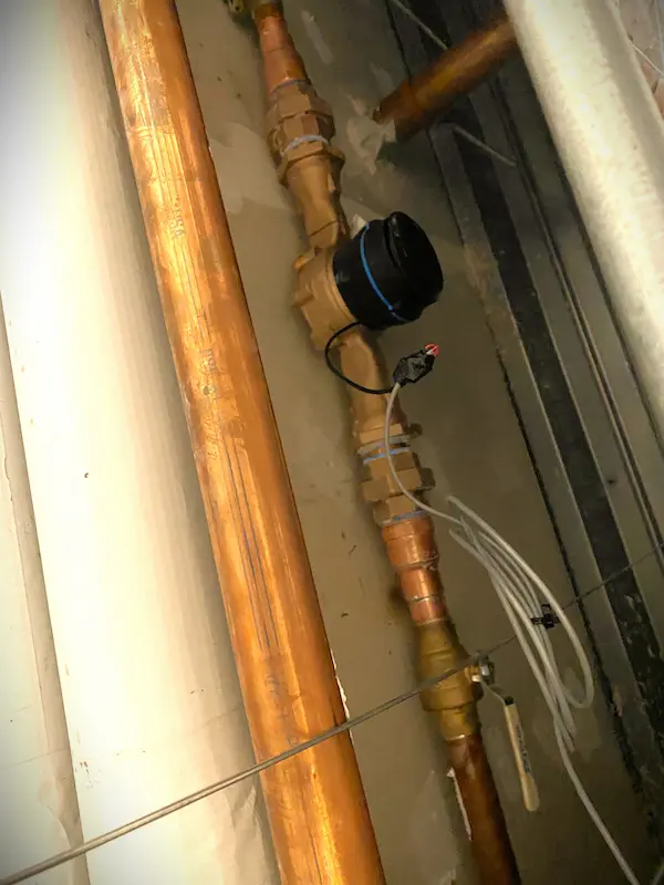 Commercial copper water supply piping with shutoff valve and backflow preventer assembly, illustrating professional commercial plumbing installation