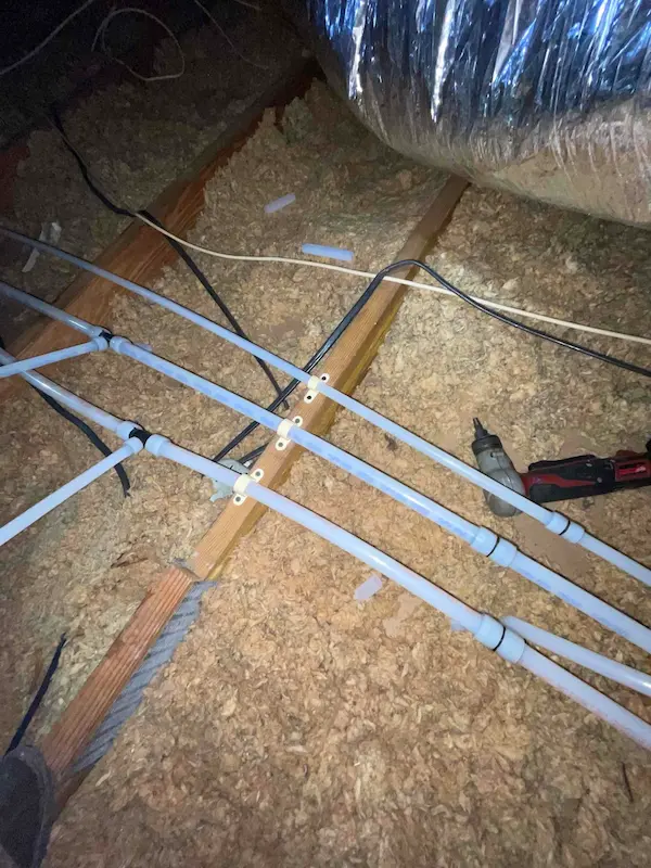 Carrollwood Village attic repipe project with new PEX water lines secured along joists, replacing old plumbing for improved reliability and flow
