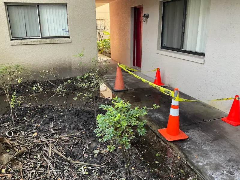 Slab leak repair jobsite in Tampa, Florida, clearly marked with traffic cones and caution tape to ensure safety for residents and pedestrians.