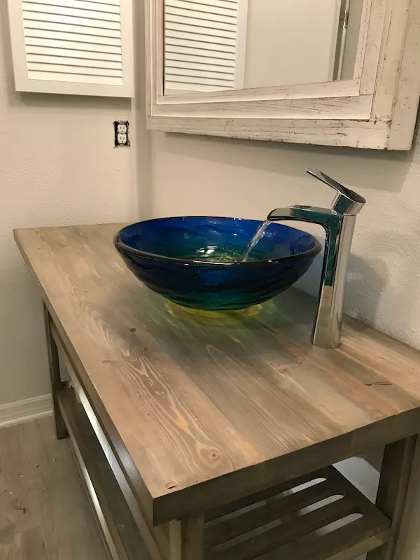 Vessel sink with modern faucet on wood vanity representing residential plumbing services in St. Petersburg by EVERYDAYPLUMBER.com