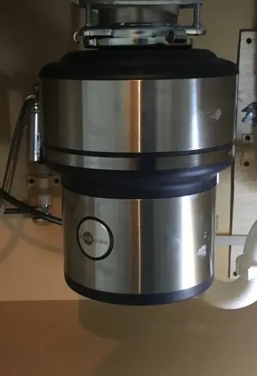 New stainless steel garbage disposal installed under a kitchen sink in a Tampa home.