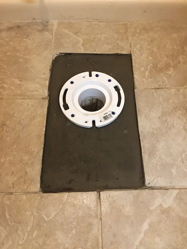 Restored toilet drain and new flange installation after complete root removal by Tampa plumber.