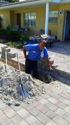 Technician excavating driveway for residential sewer line repair in Tampa