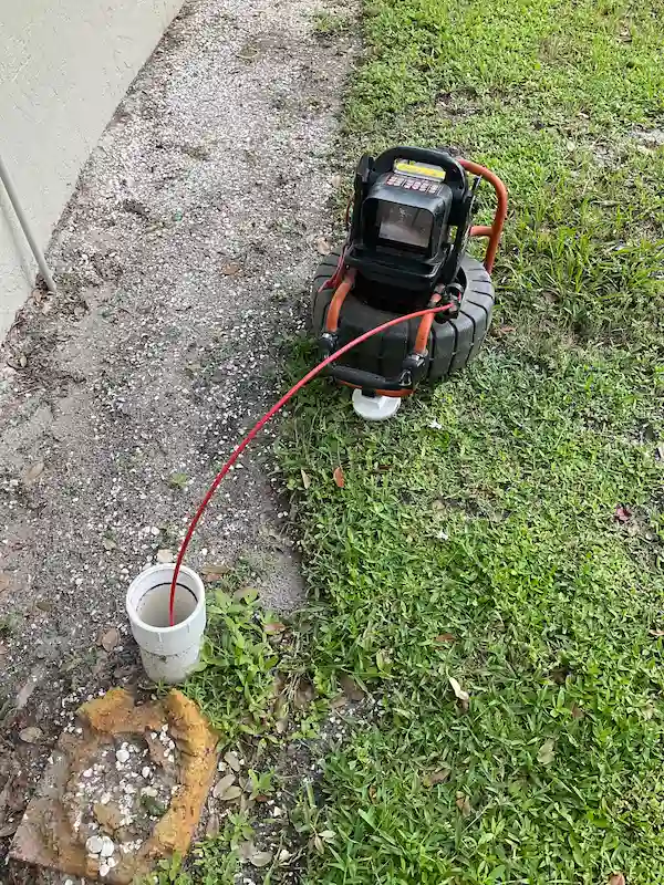 Push-rod sewer camera inspecting a residential drain line through an exterior cleanout in Ybor City