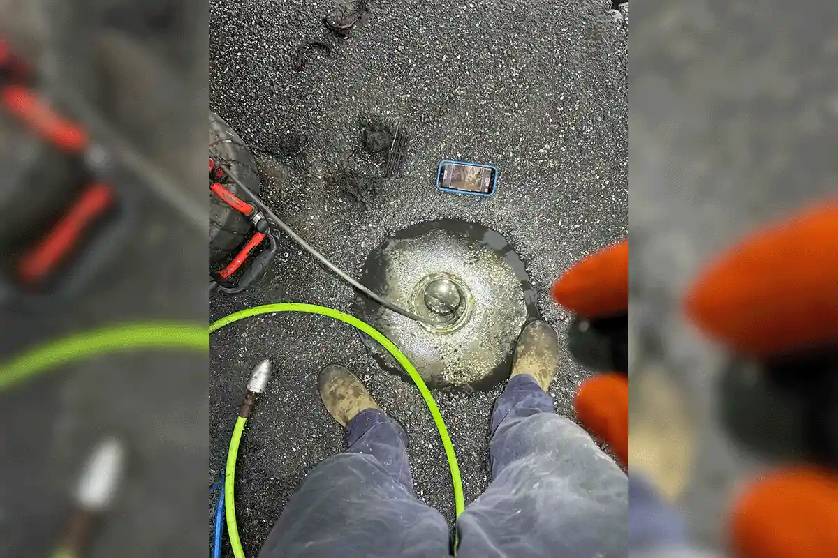 EVERYDAYPLUMBER.com technician performing camera inspection during hydro jetting service — live drain footage on phone screen, Tampa Bay