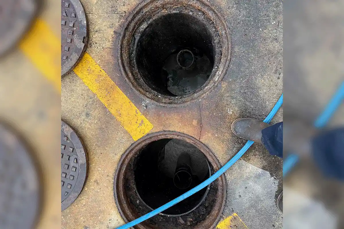 Commercial hydro jetting service in progress — dual manhole access with high-pressure hose — EVERYDAYPLUMBER.com Tampa Bay