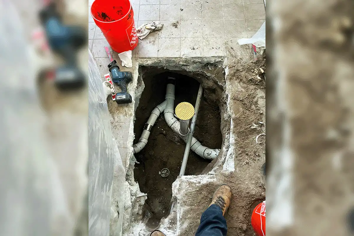 EverydayPlumber.com plumber repairing commercial drain lines exposed through a broken concrete slab floor in a Tampa Bay commercial facility