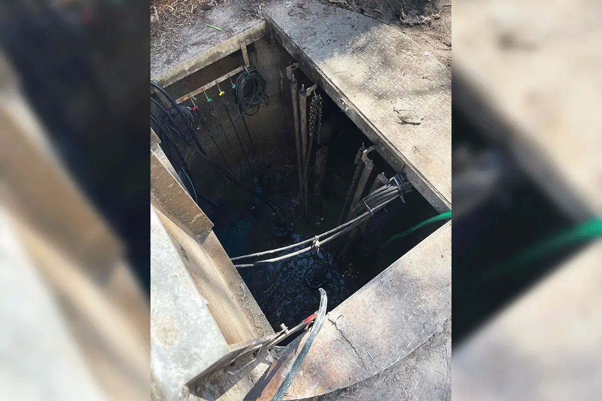 Open commercial lift station wet well with pump cables and wiring accessible for service in Tampa Bay
