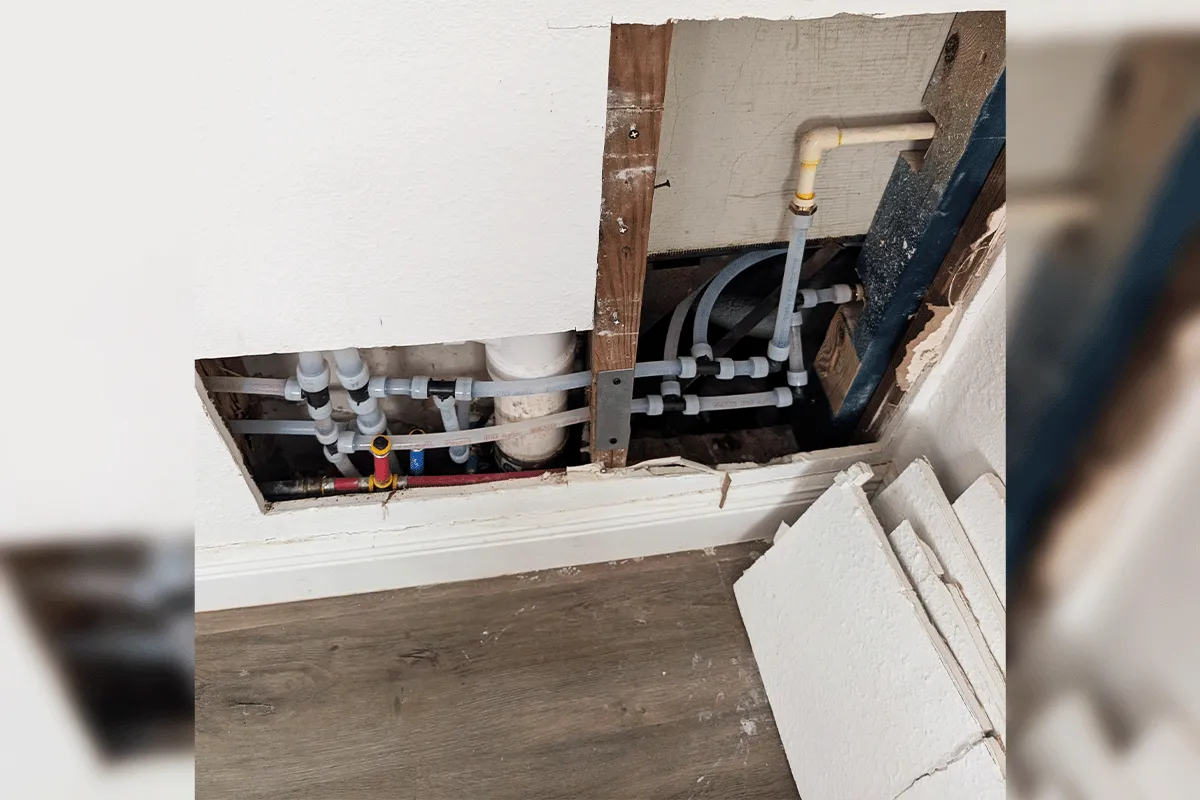 PEX supply line manifold and shutoff valves installed through a drywall access opening during a whole house repipe by EverydayPlumber.com in Tampa Bay