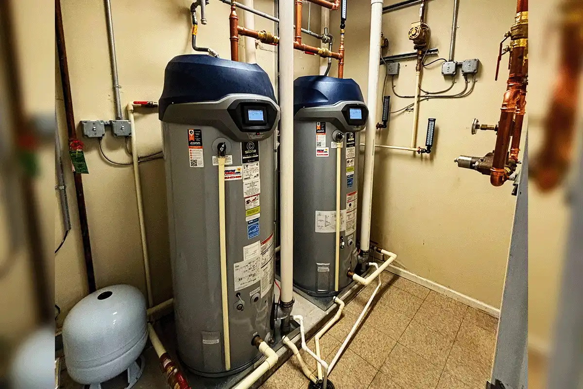 Dual commercial hybrid heat pump water heaters installed in utility room with copper piping — commercial water heater installation Tampa