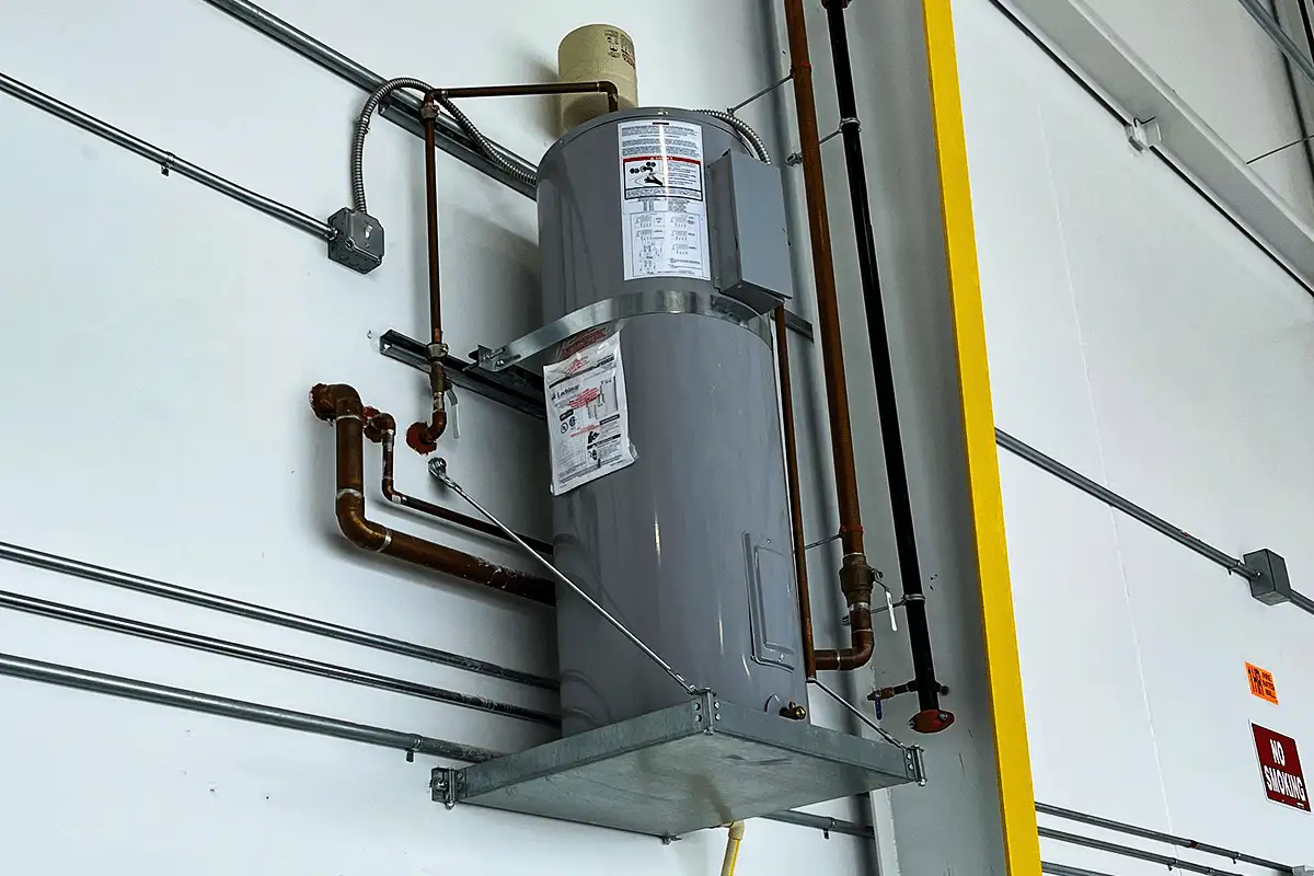 Commercial water heater mounted on wall bracket with copper supply lines in commercial facility — commercial water heater installation Tampa
