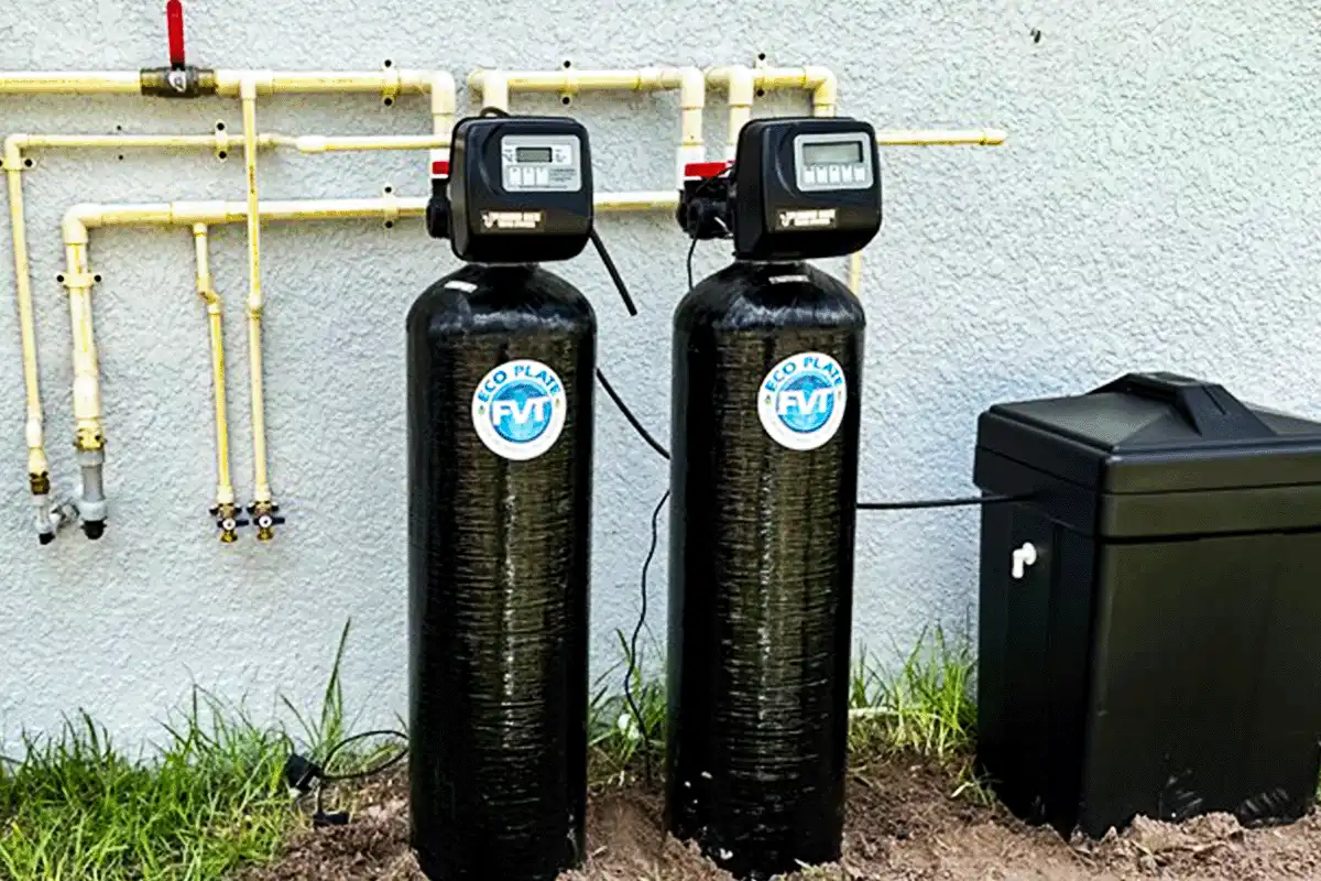 Dual-tank whole-house water softener system installed on exterior wall of Tampa Bay home
