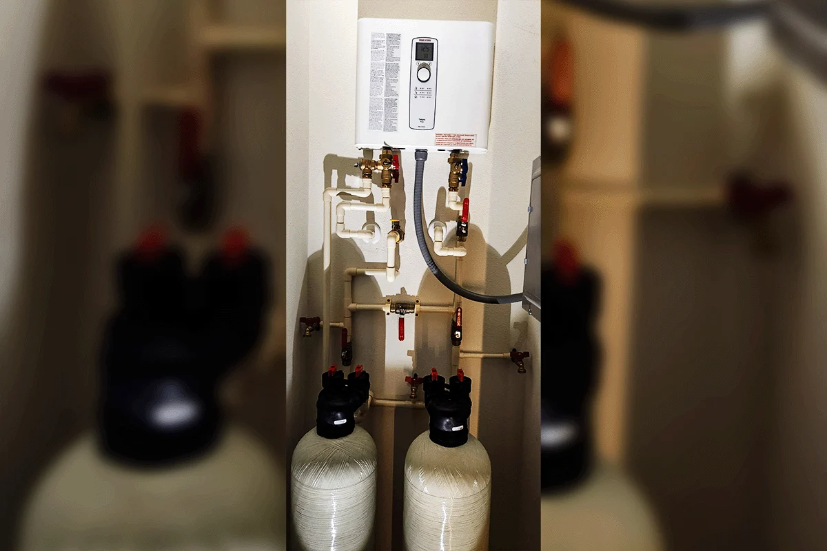 Dual water softener tanks installed alongside tankless water heater — whole-house water treatment protecting plumbing