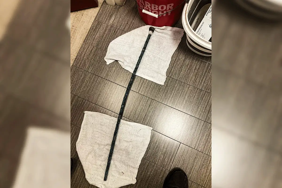 Completely depleted and blackened anode rod removed from a Tampa Bay residential water heater — showing severe corrosion caused by Tampa Bay's hard water mineral content, demonstrating why anode rod inspection every 3 years is essential in this market