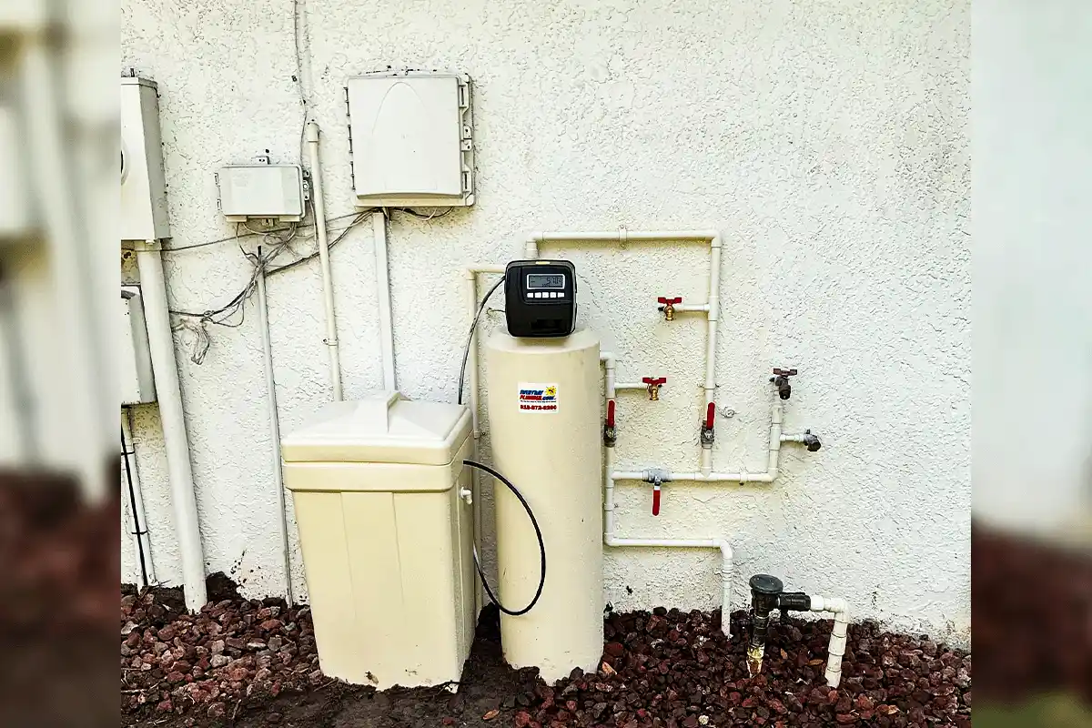 EverydayPlumber.com branded whole-house water softener installed on the exterior stucco wall of a Tampa Bay home — showing salt tank, digital control head, PVC bypass manifold, and ball valve connections that protect water heaters and all plumbing appliances from Tampa Bay hard water damage