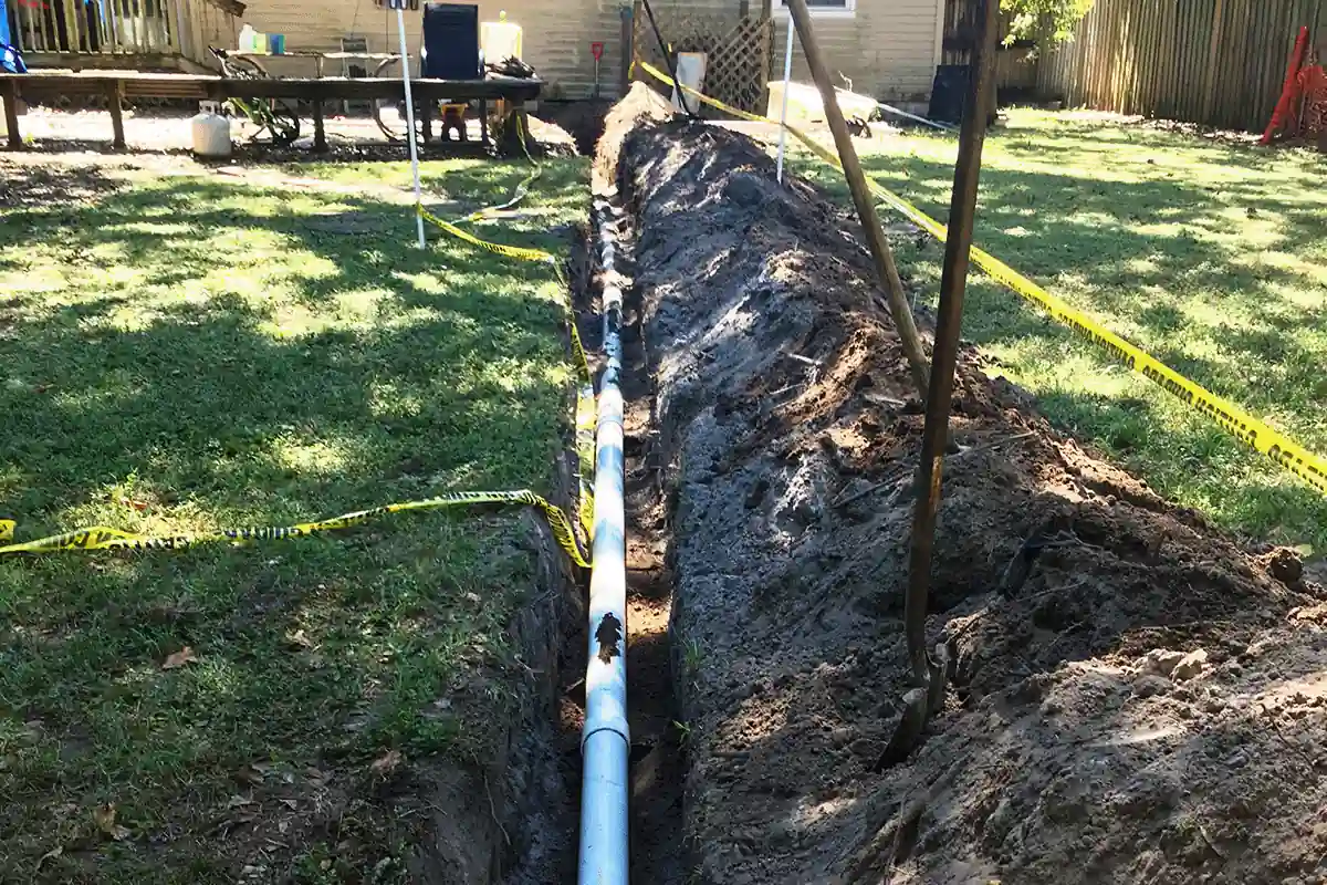 New sewer line installed in residential yard trench with caution tape — sewer repair and replacement in Clearwater FL — EVERYDAYPLUMBER.com