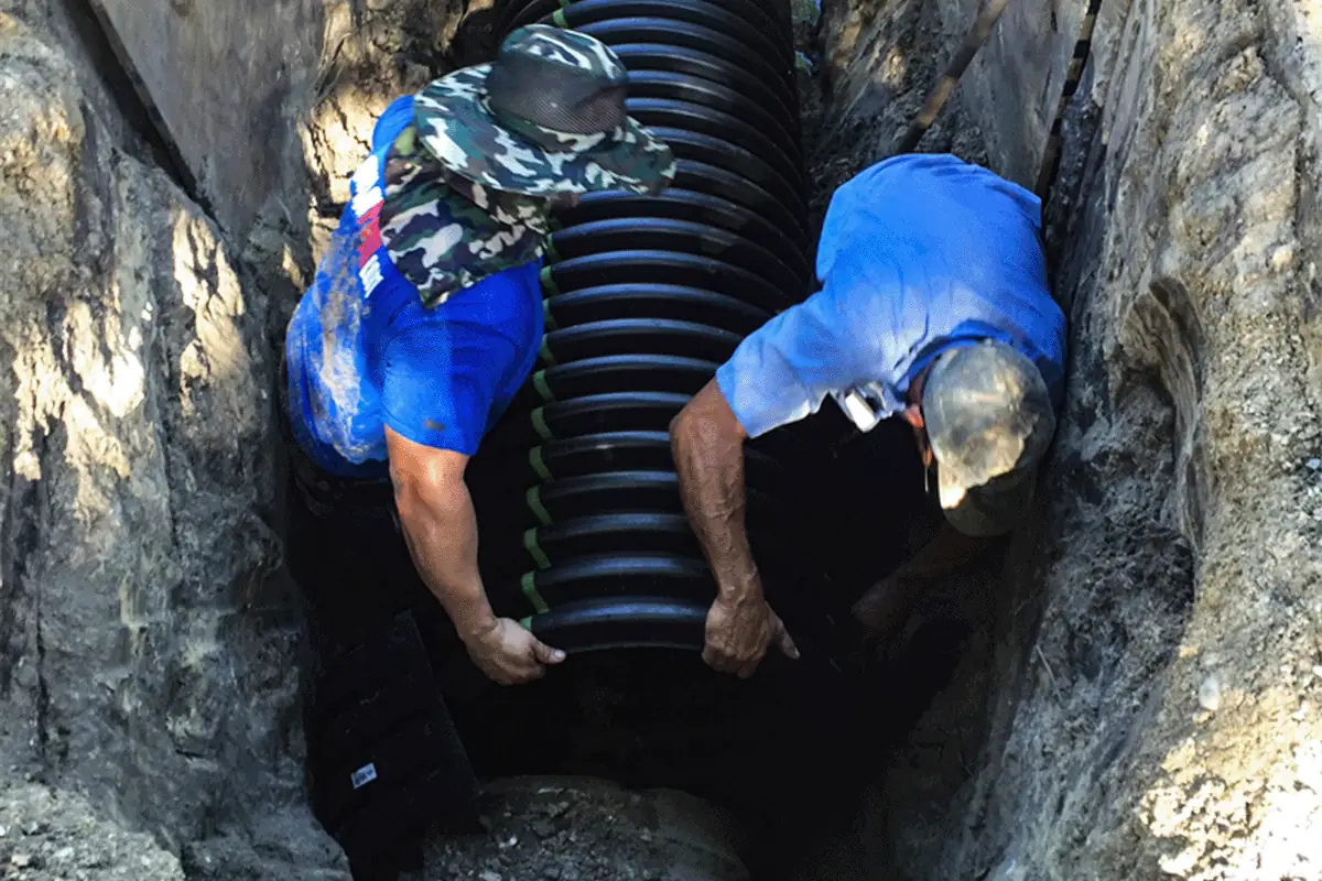 Plumbing crew lowering large diameter sewer pipe into excavated trench — sewer line installation in Clearwater FL — EVERYDAYPLUMBER.com