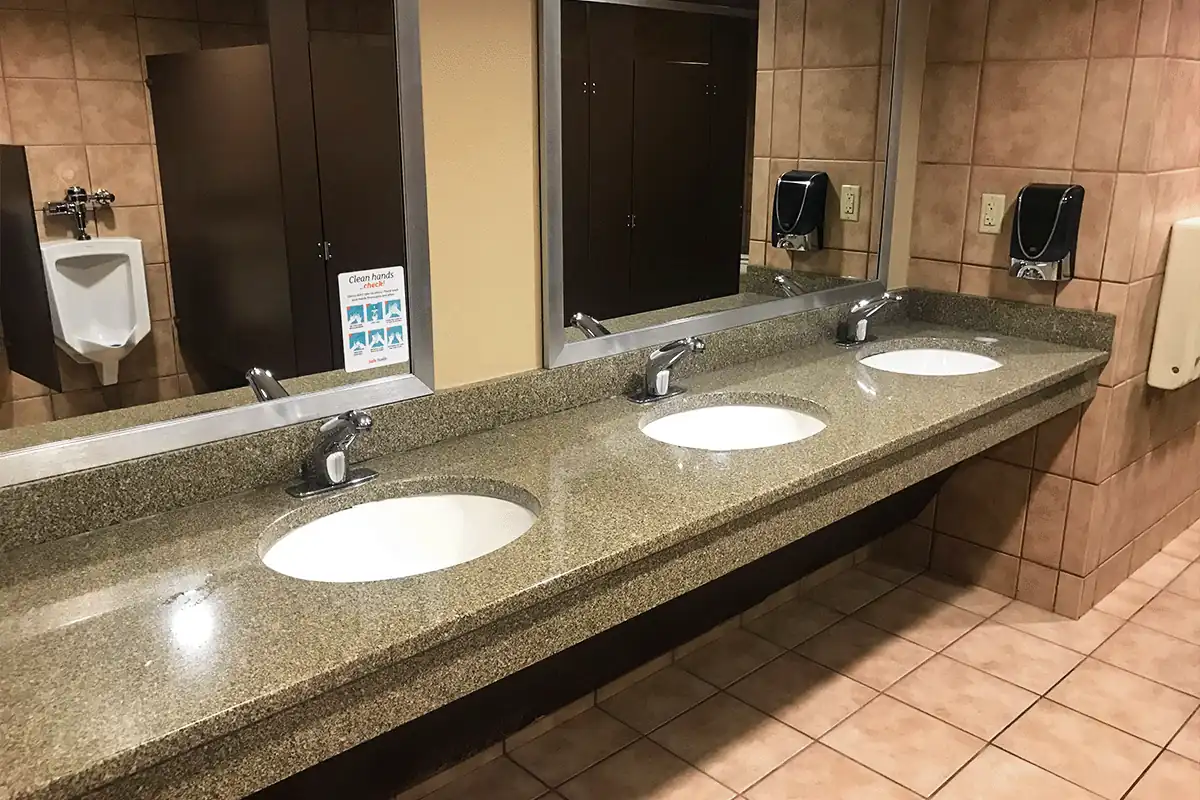 Commercial bathroom with multi-sink vanity, sensor faucets, and urinal — commercial plumbing services in Brandon FL — EVERYDAYPLUMBER.com