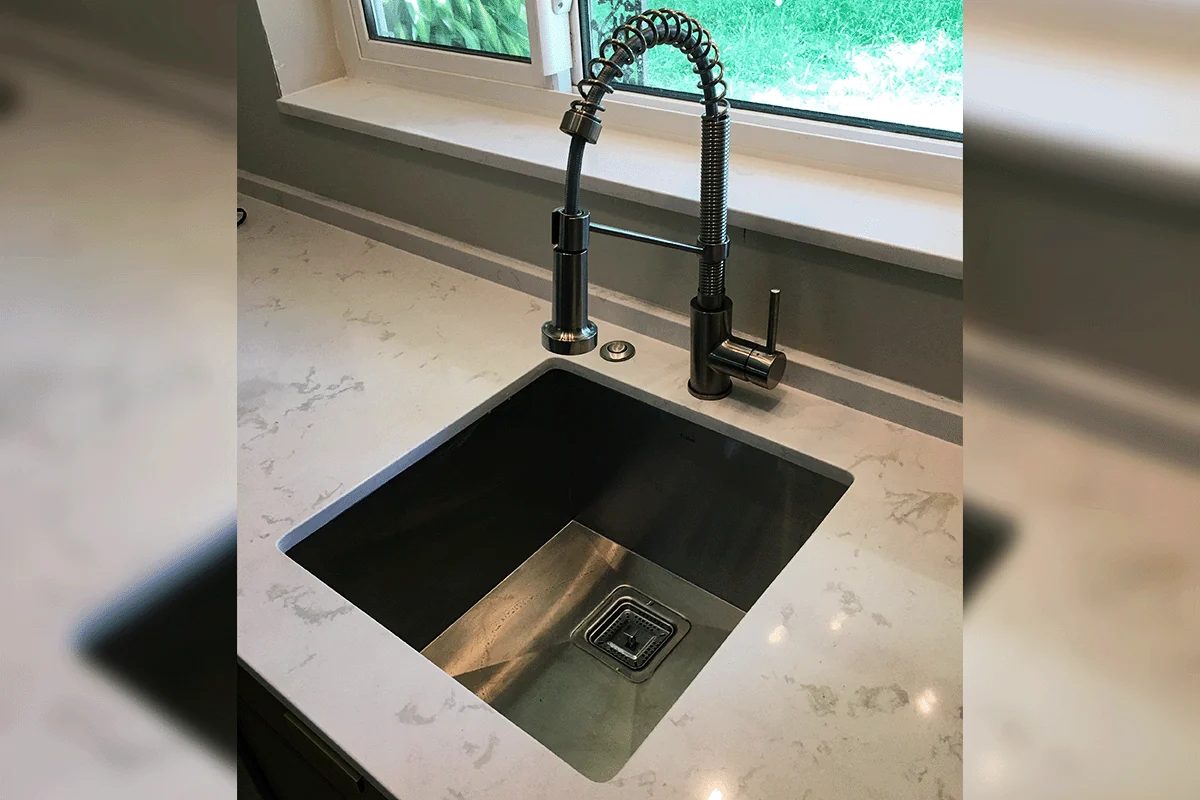 Modern undermount kitchen sink and industrial coil faucet installed on quartz countertop — plumbing installation in Brandon FL — EVERYDAYPLUMBER.com