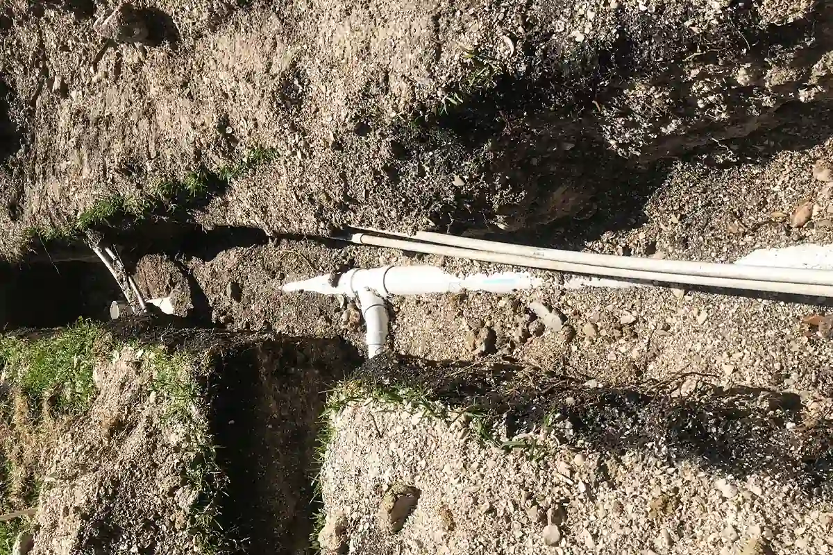Overhead view of residential sewer line trench with new PVC pipe laid in sandy soil — sewer repair and replacement Wesley Chapel — EVERYDAYPLUMBER.com Wesley Chapel