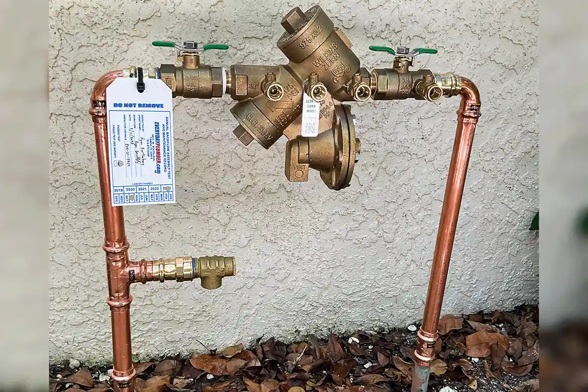edp-tampa-backflow-preventer-copper-pipe-installation-2026 Brass backflow preventer assembly with copper pipe installed by licensed Tampa plumber — EVERYDAYPLUMBER.com Tampa
