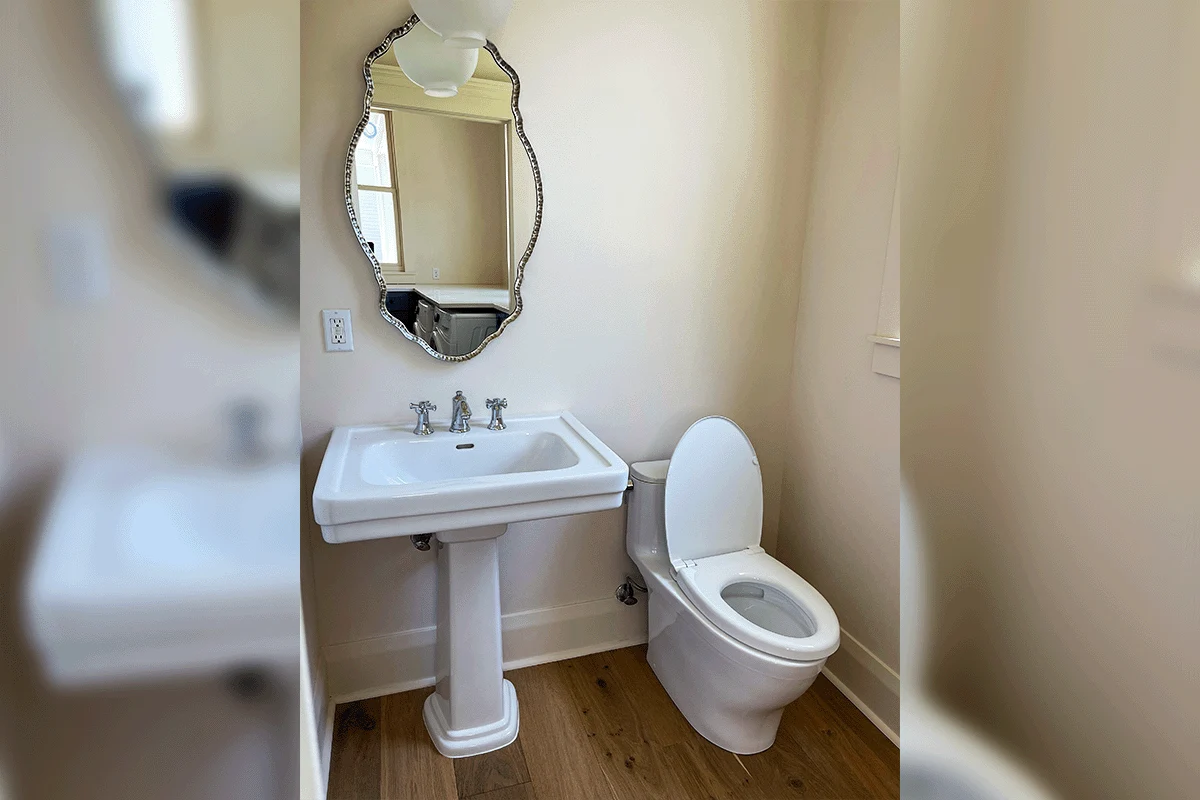 edp-toilet-repair-residential-bathroom-installation-2026 Completed residential bathroom installation showing one-piece toilet and pedestal sink with finished flooring — toilet installation Tampa Bay — EVERYDAYPLUMBER.com Tampa Bay