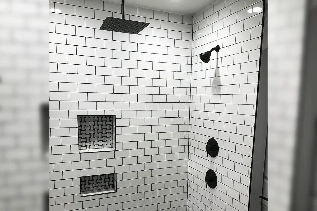 edp-black-shower-subway-tile-2026 Black finish shower fixtures on white subway tile with mosaic niche — shower valve installation — EVERYDAYPLUMBER.com Tampa Bay
