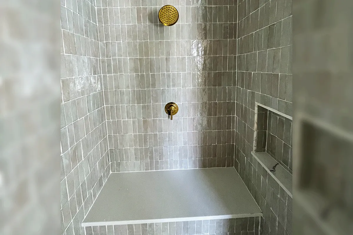 edp-brass-valve-gray-tile-bench-2026 Brass single-handle shower valve with rainfall head and built-in bench — shower valve installation — EVERYDAYPLUMBER.com Tampa Bay